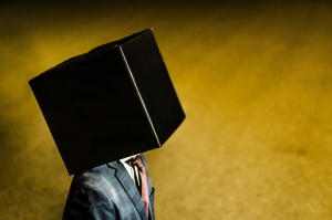 a man wearing a suit with his head in a box